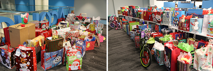 A large collection of holiday gift bags, boxes, and toys gathered in an office for a donation drive.