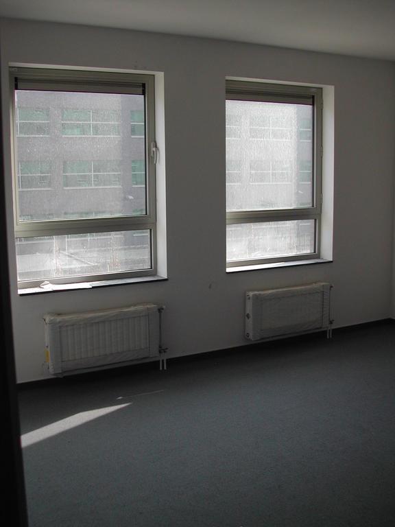 Empty bedroom with two large windows and radiators, taken before moving in March 2003.