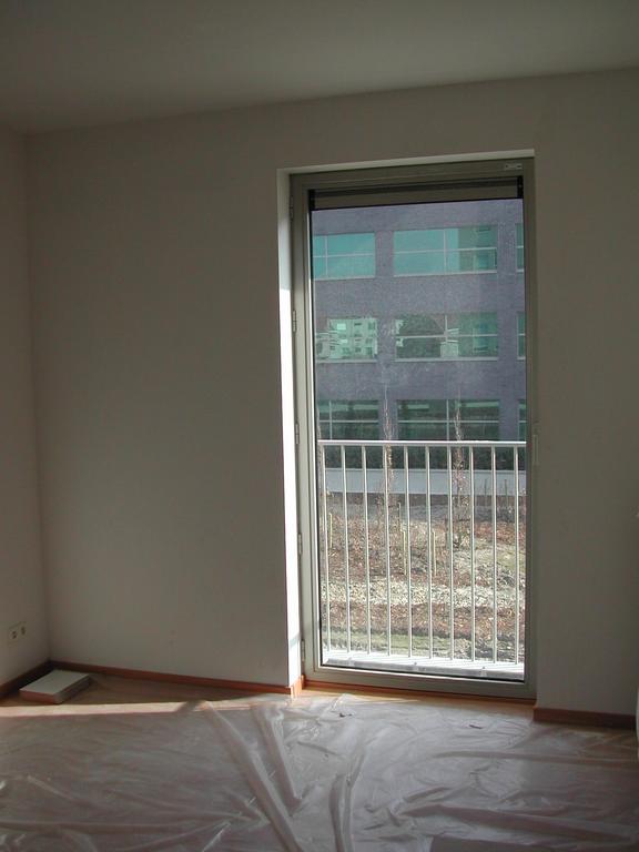 Empty office room with a large window and plastic covering on the floor, taken before the move in 2003.