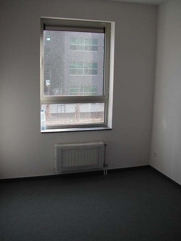 An empty small bedroom with a window, radiator, and plain walls, photographed before moving in March 2003.