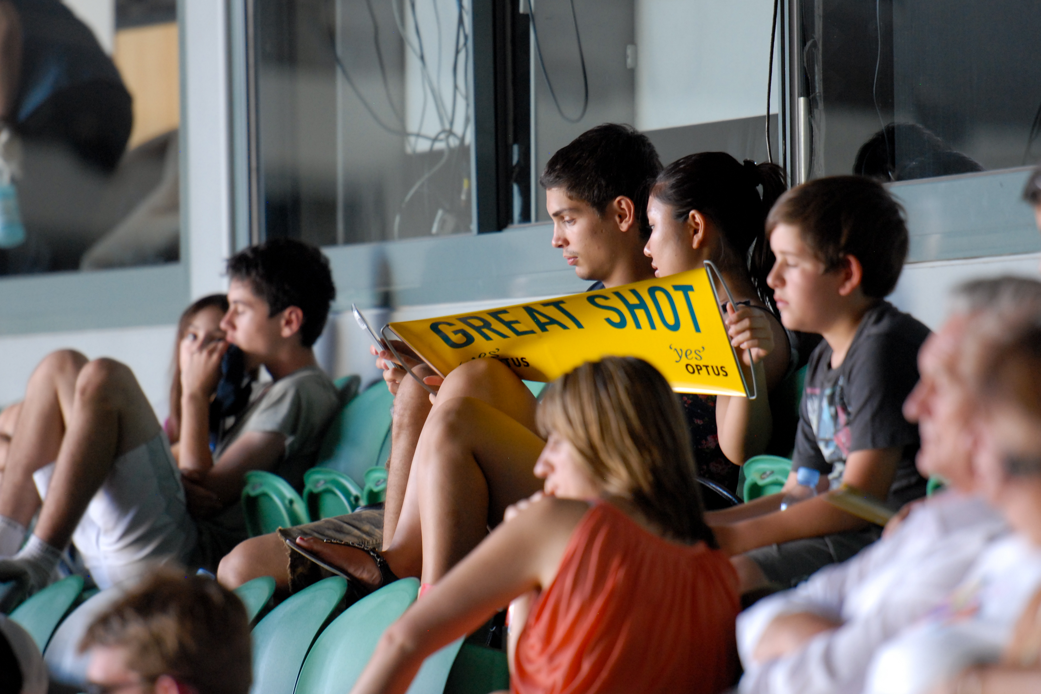 Spectators in the stands hold a "Great Shot" sign while watching the Klijsters vs.