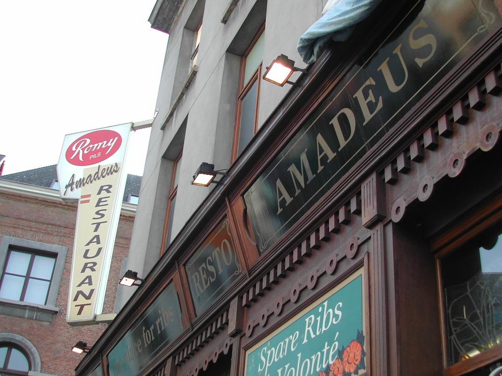 The exterior of "Amadeus" restaurant with signage advertising spare ribs and a "Romy Pils" beer sign.