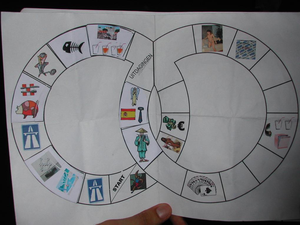 A hand holds a printed board game with various illustrated spaces, likely related to a bachelor party pub crawl.