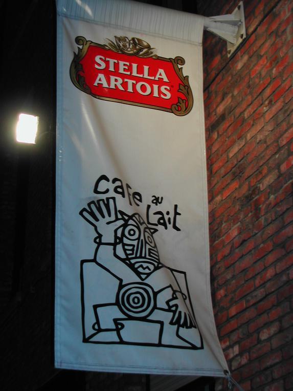 A hanging banner with a Stella Artois logo and a black-and-white drawing labeled "Café au Lait.
