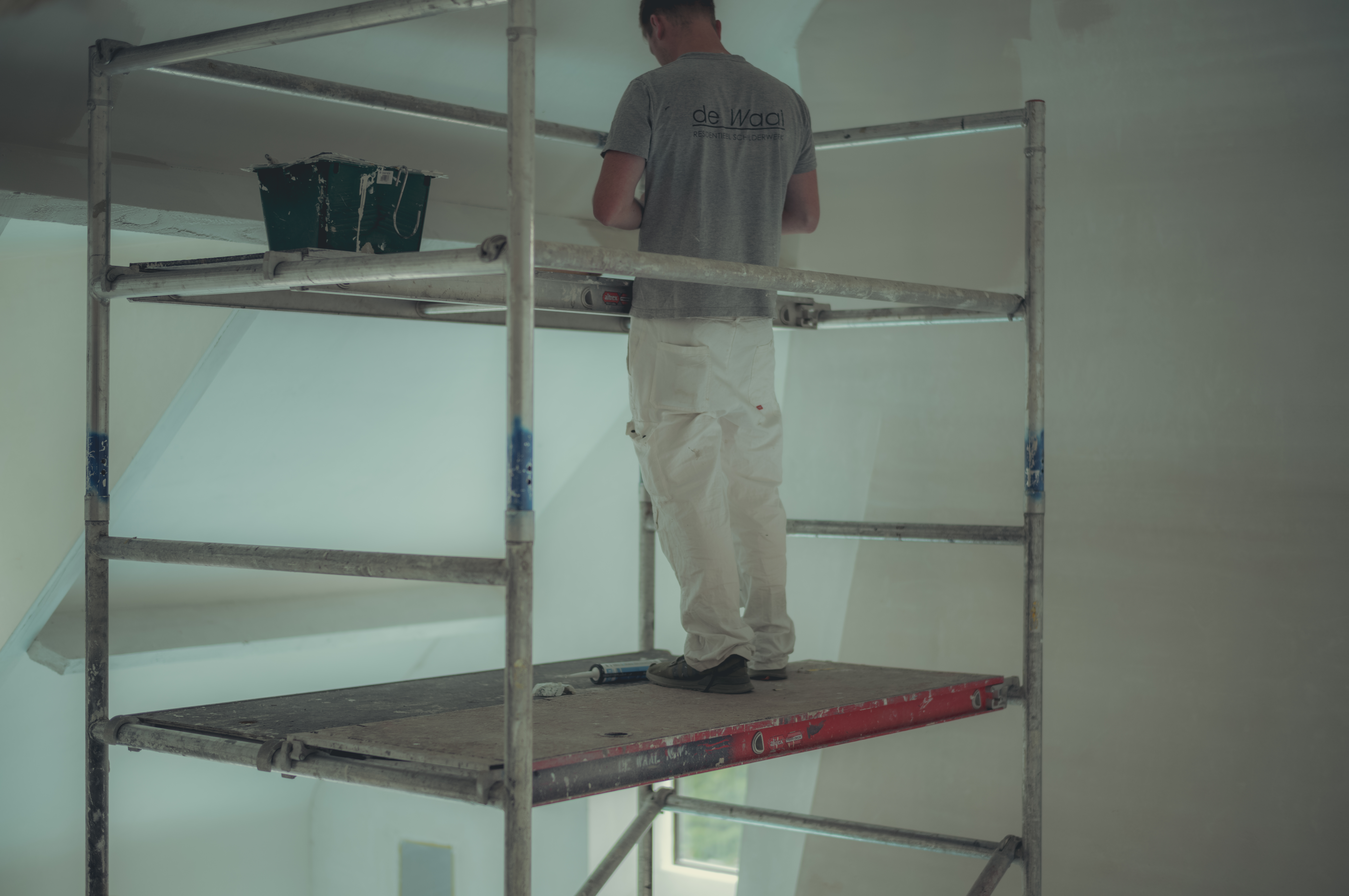A painter on scaffolding preparing to paint the ceiling.