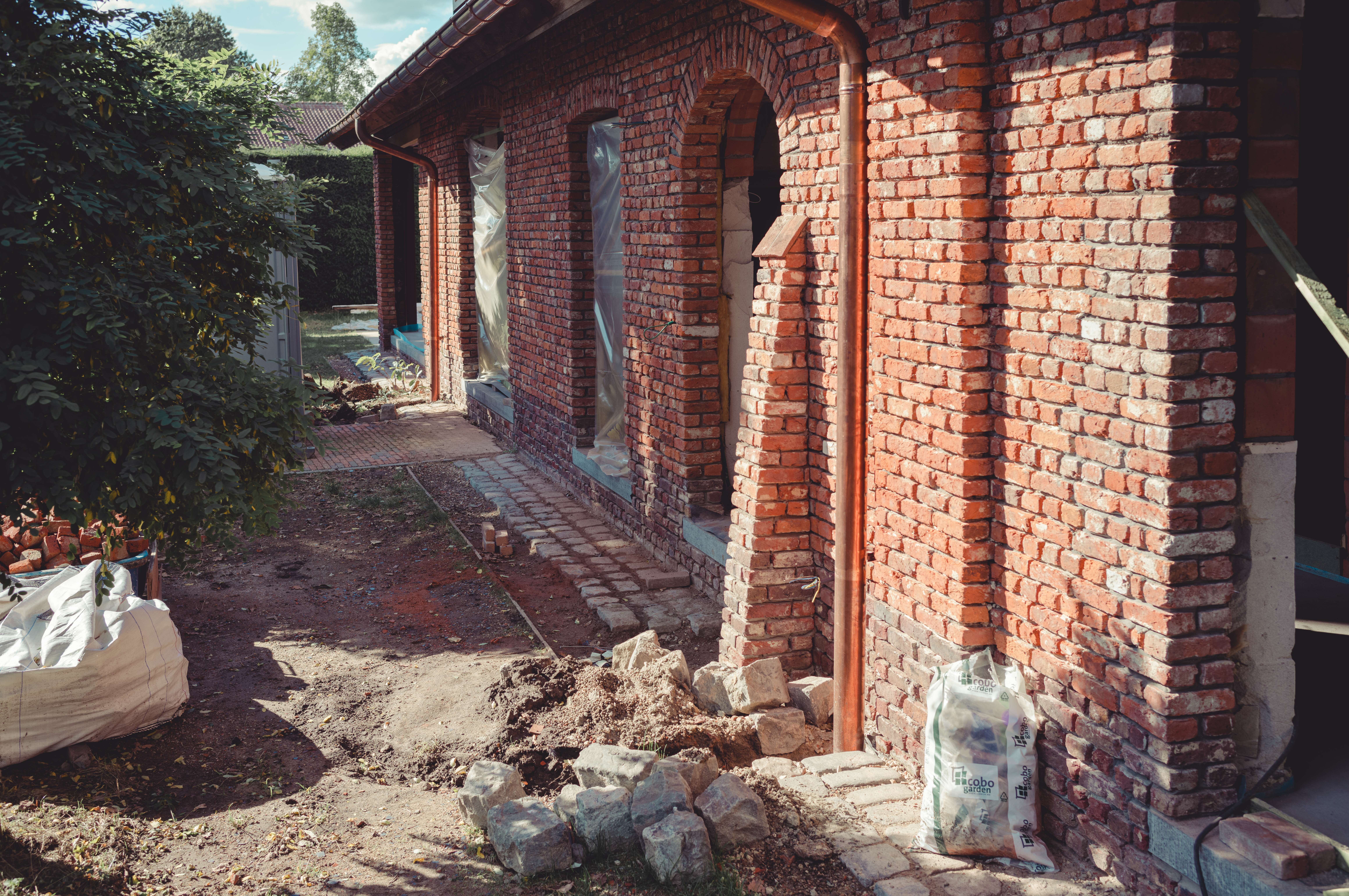 A brick building facade with old mortar removed, preparing for repointing.