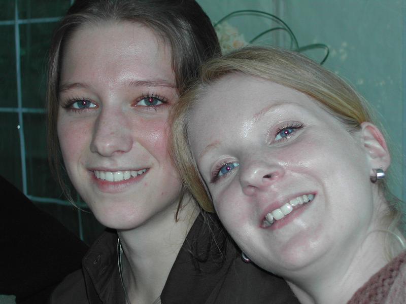 Two women smiling closely together at a communion party.