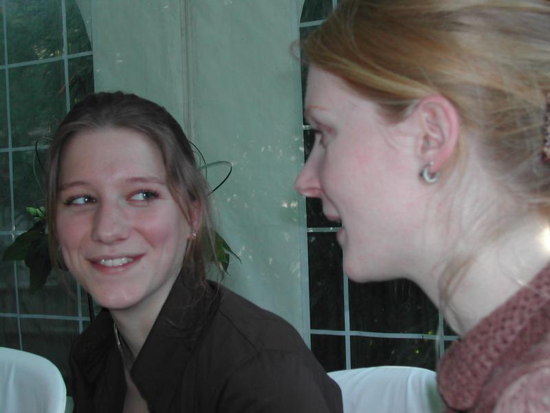 Two women sitting and smiling at each other during a conversation at a communion party.