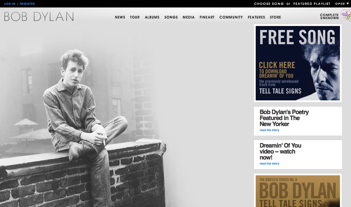 Black-and-white image of a man sitting on a brick ledge, with a website featuring Bob Dylan content in the background.
