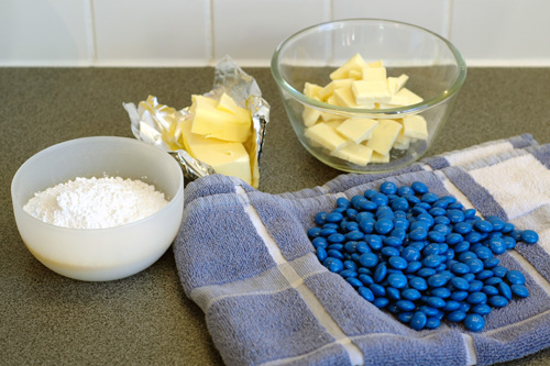 Sugar, butter, cream, m&amp;m's and white chocolate displayed in bowls