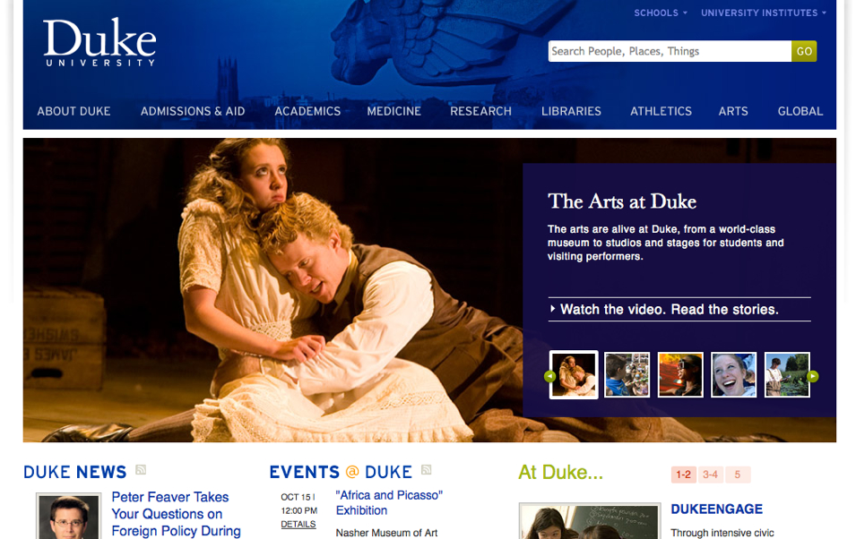 Two actors perform an emotional scene on stage, with one embracing the other.