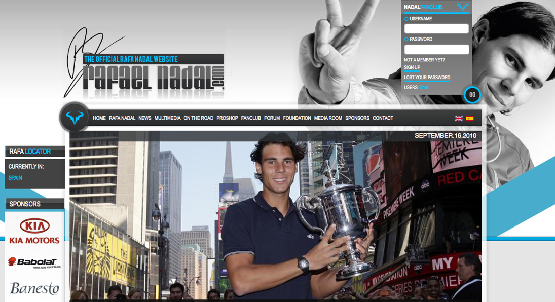 Rafael Nadal smiles while holding a large trophy outdoors.