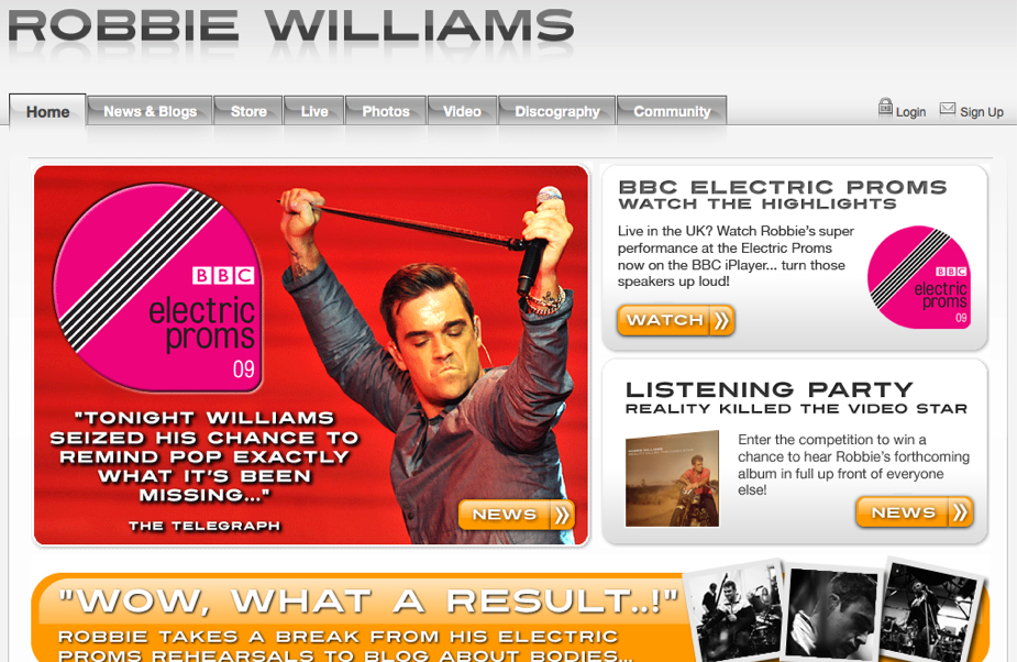 A singer in a red jacket performs on stage, holding a microphone.