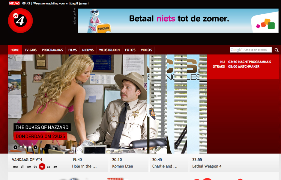 A police officer in uniform sits at a desk while a woman in a pink outfit leans toward him.