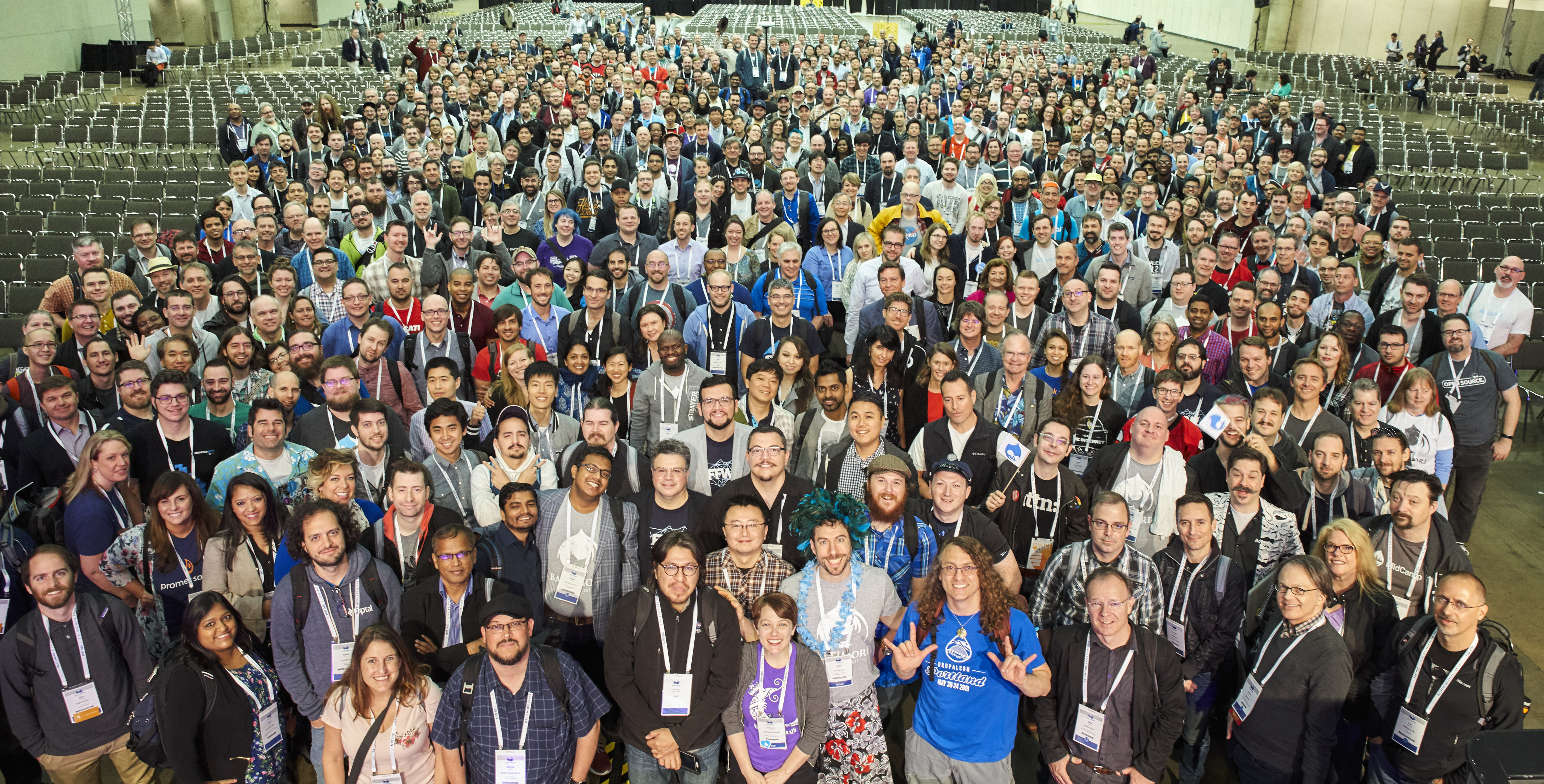 A large group of DrupalCon Baltimore 2017 attendees pose together for a group photo in a conference hall.