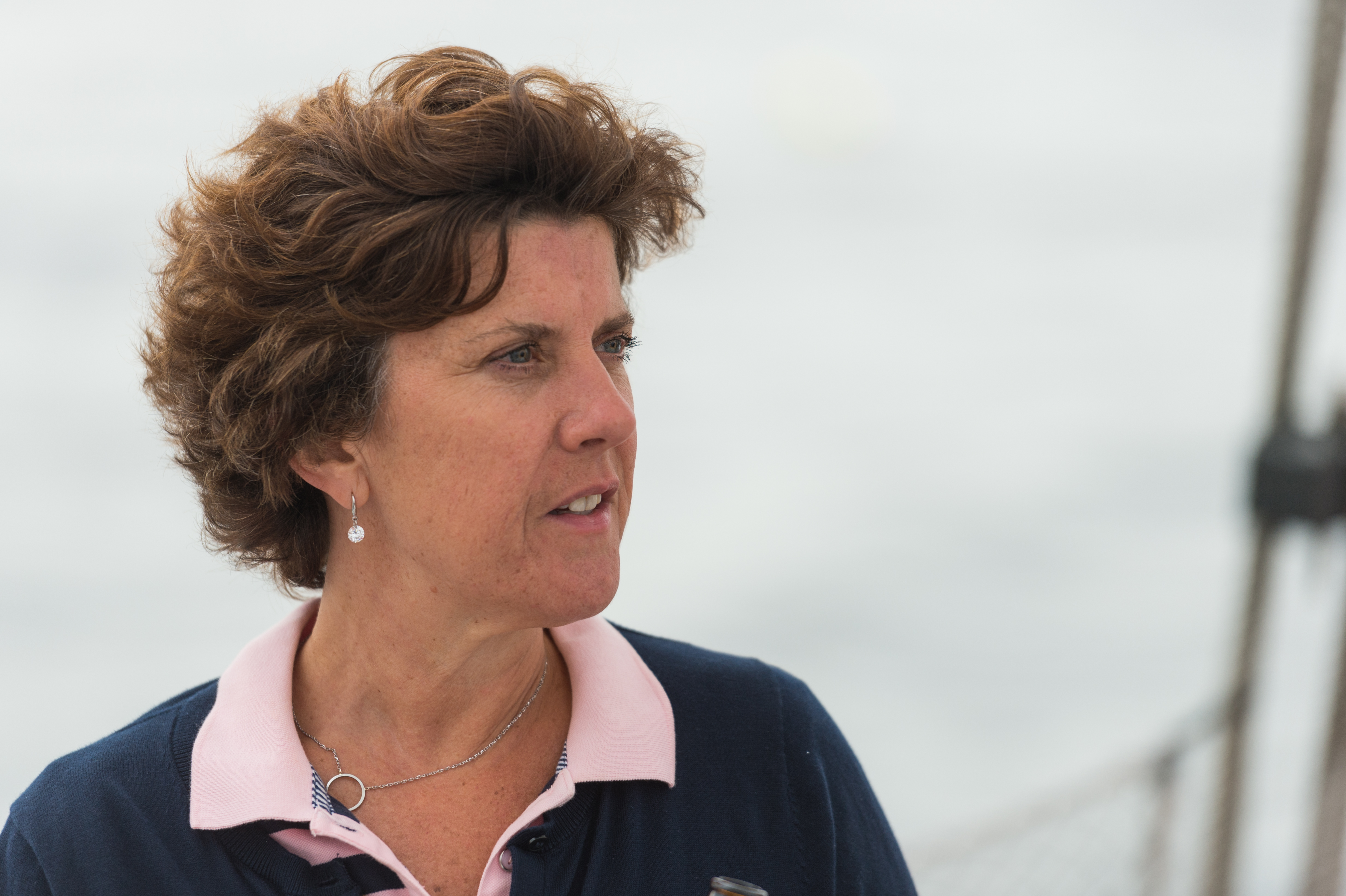 A woman on a boat looks to the side with a focused expression.