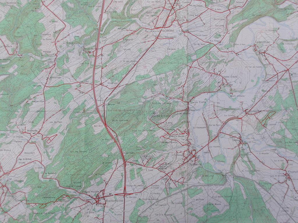 A detailed topographic map showing roads, elevation, and natural features with red lines marking routes and locations.