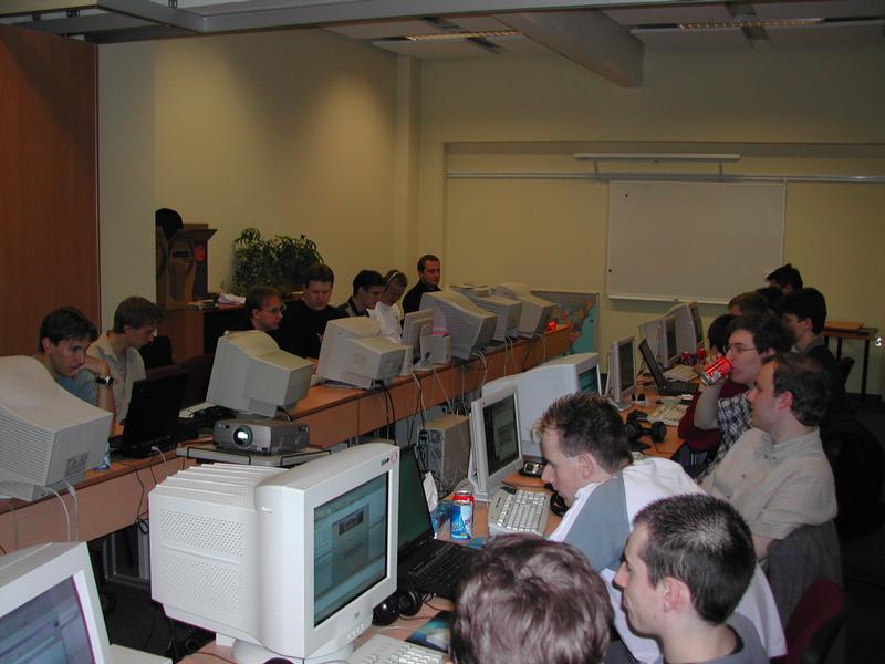 A group of people sitting at desks with computers, focused on screens during a LAN party.