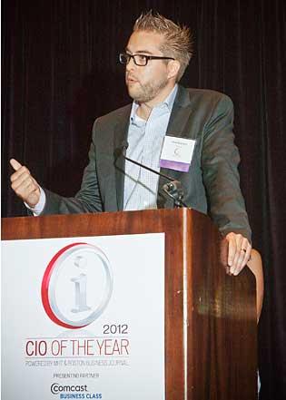 A man in a suit speaks at a podium during the 2012 CIO of the Year event.