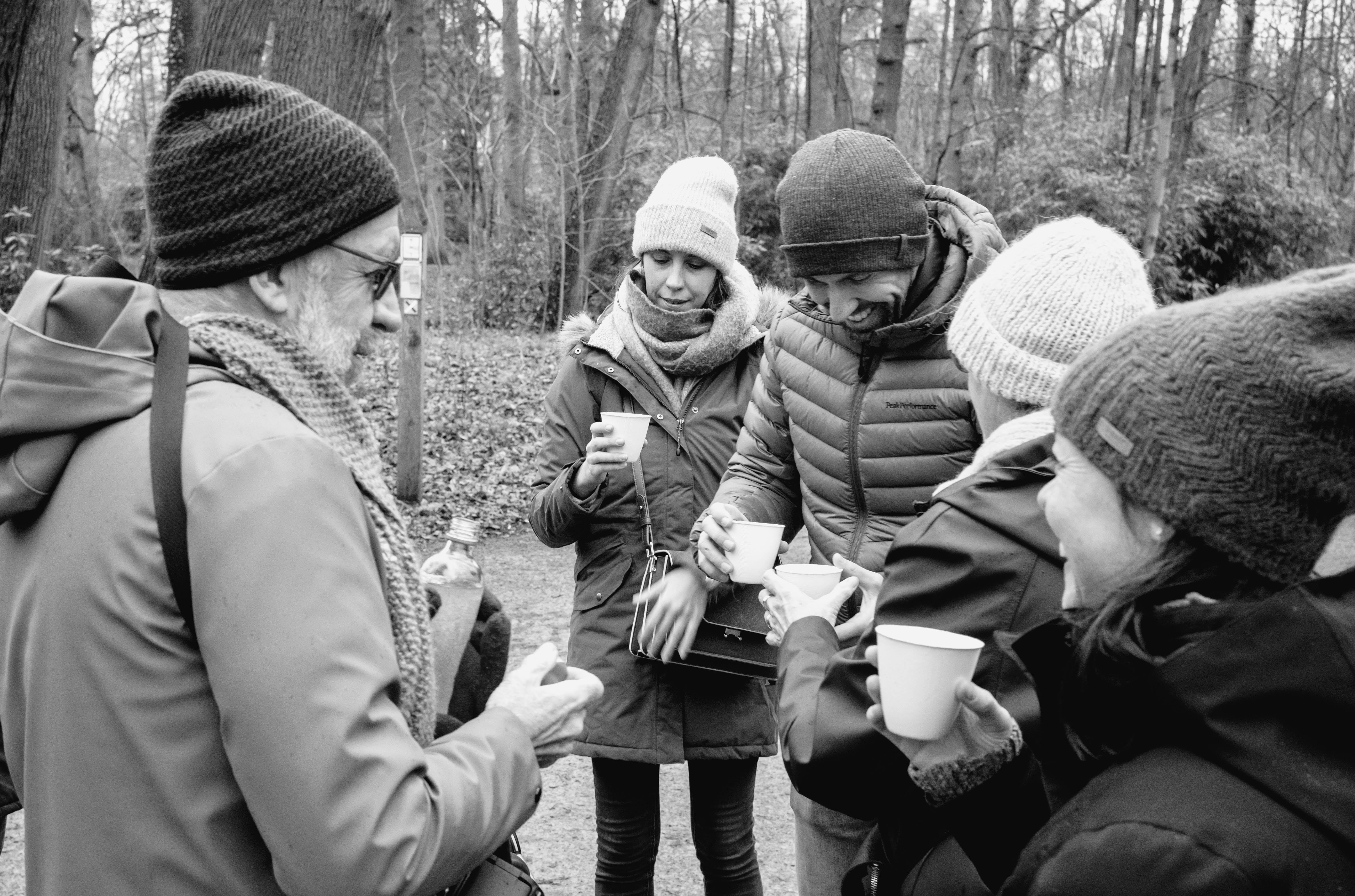 People standing outside drinking jenever.