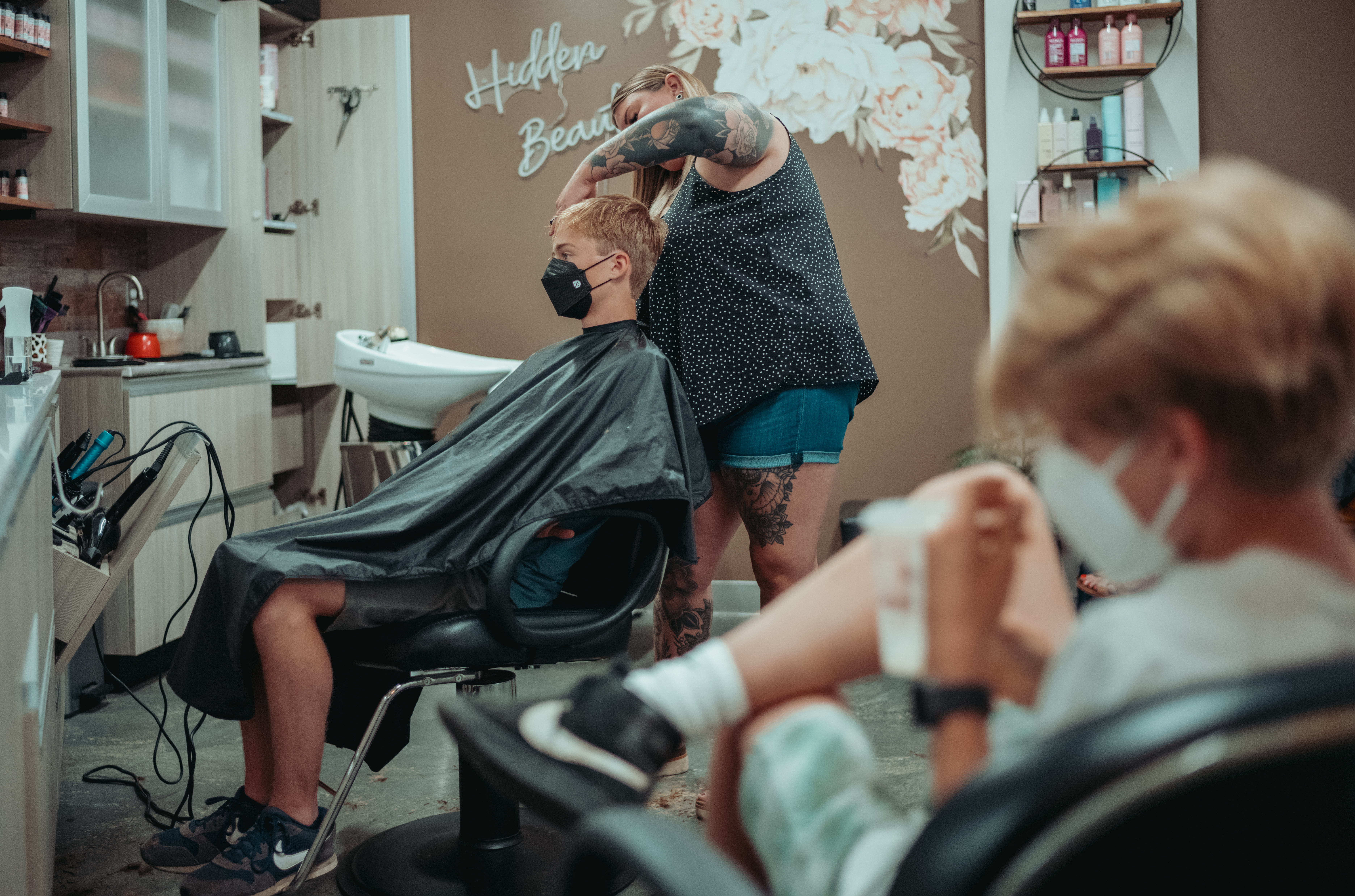 A woman giving a boy a haircut in a salon.