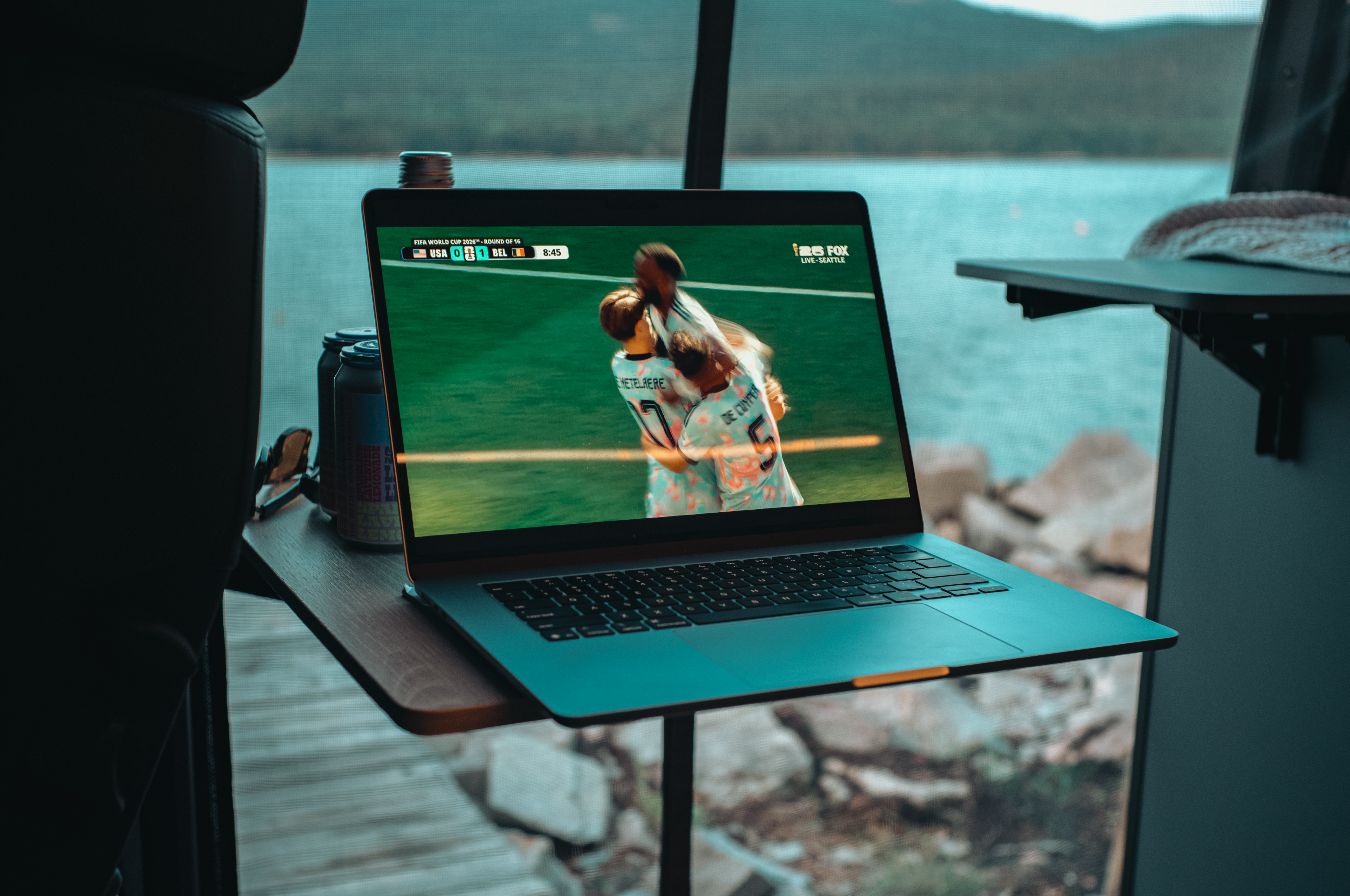Open van doors looking out over the water in Acadia National Park, with a laptop showing the Belgium vs USA 2026 World Cup game.