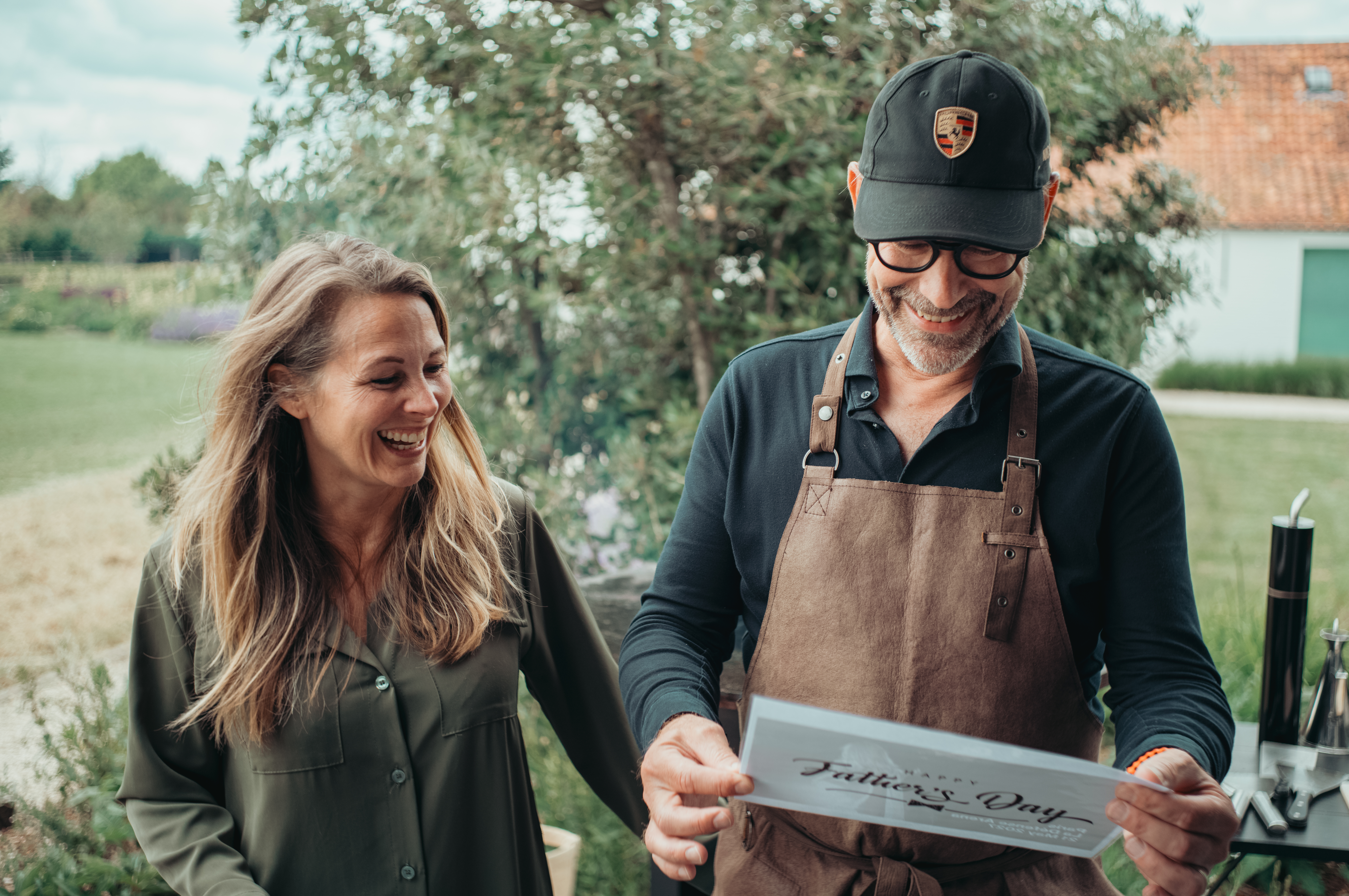 A woman gives her husband a Father's Day gift at a summer barbecue.