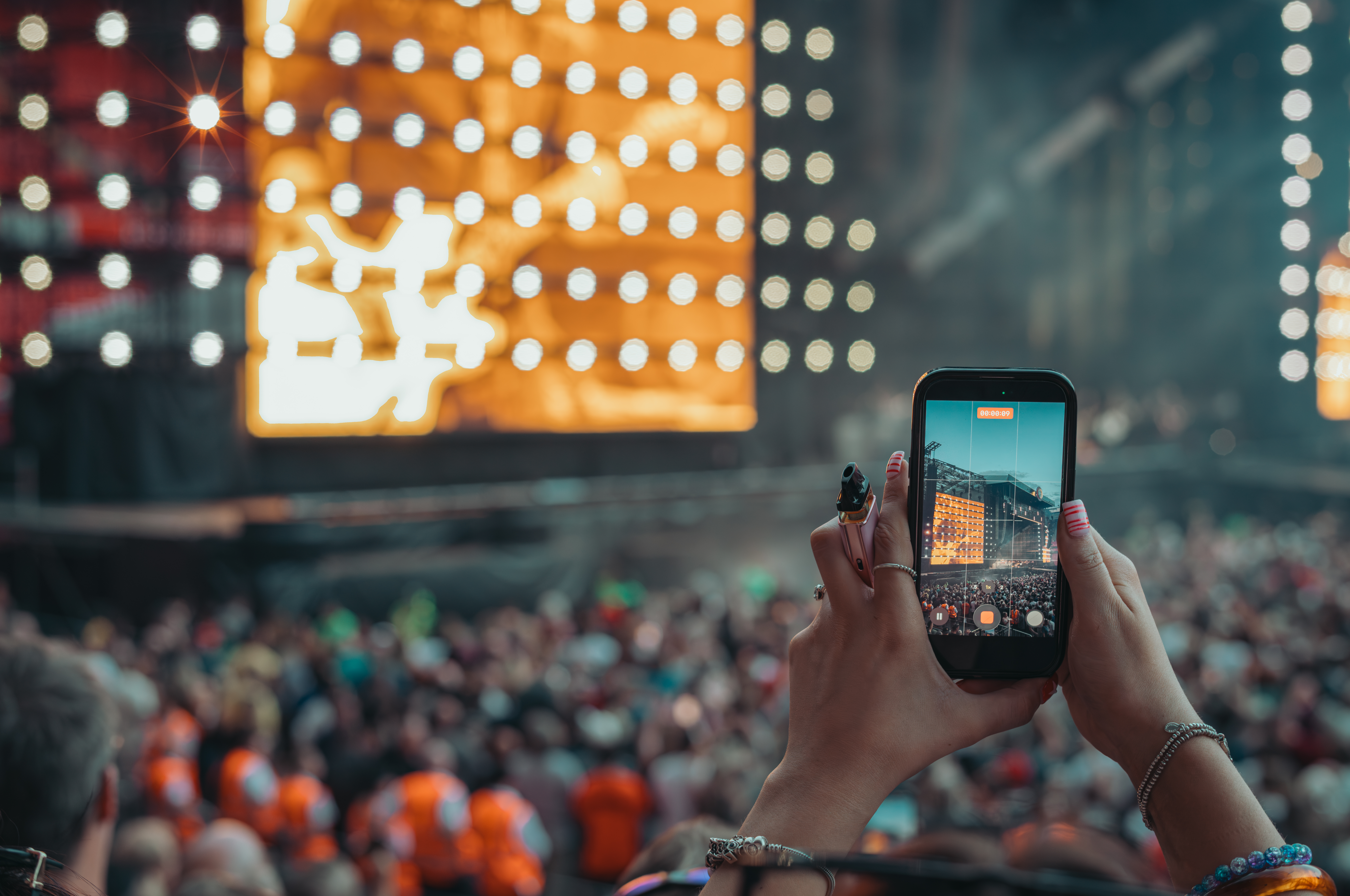 A concertgoer records Foo Fighters on their phone in Liverpool, UK.