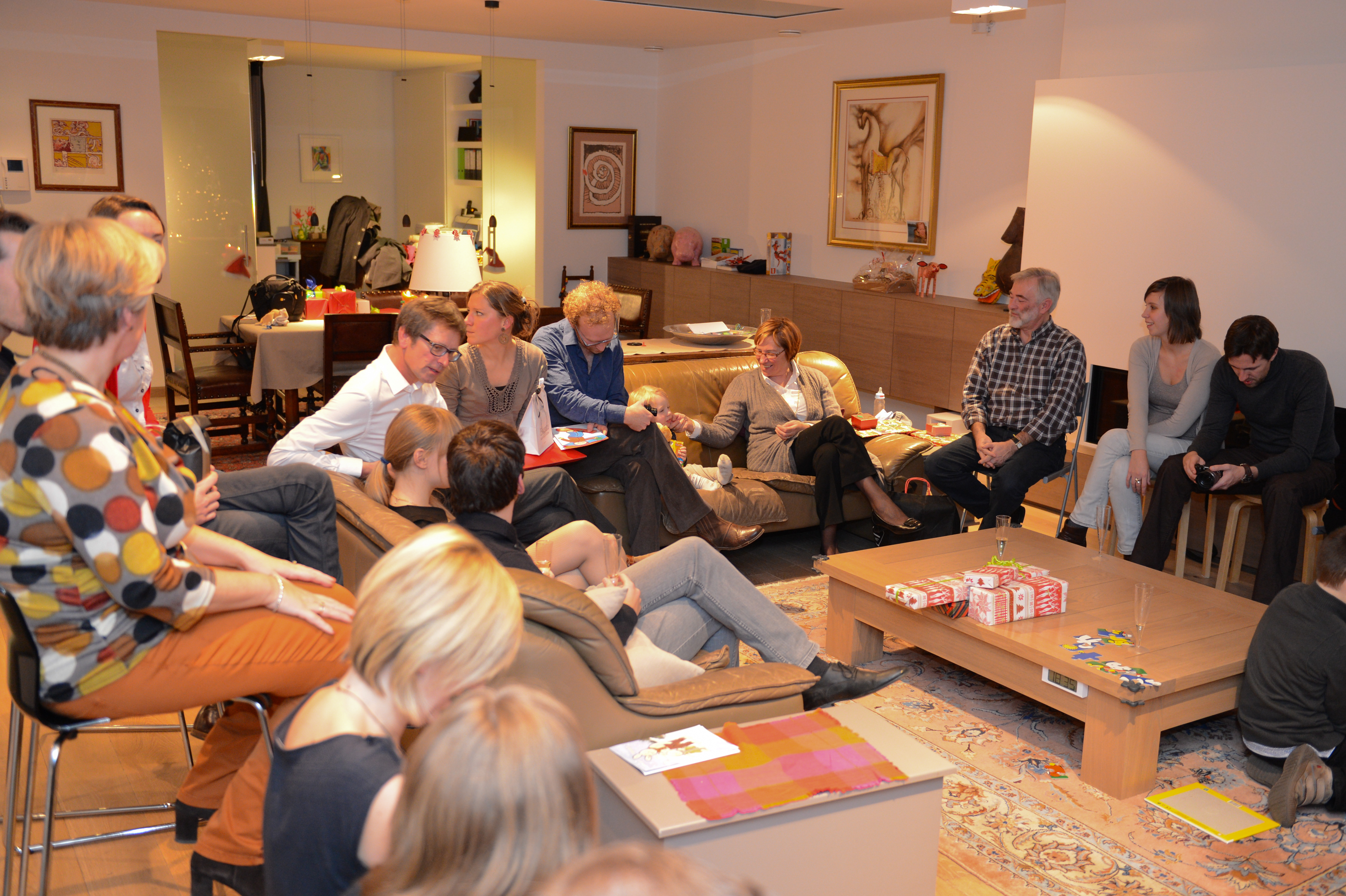 A group of people gathered in a living room, talking and enjoying a New Year's party.
