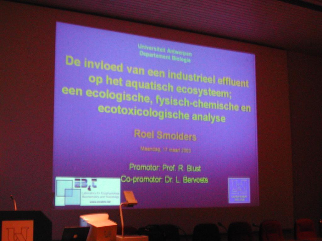 A presentation slide displays the title and details of Roel Smolders' PhD defense at the University of Antwerp.