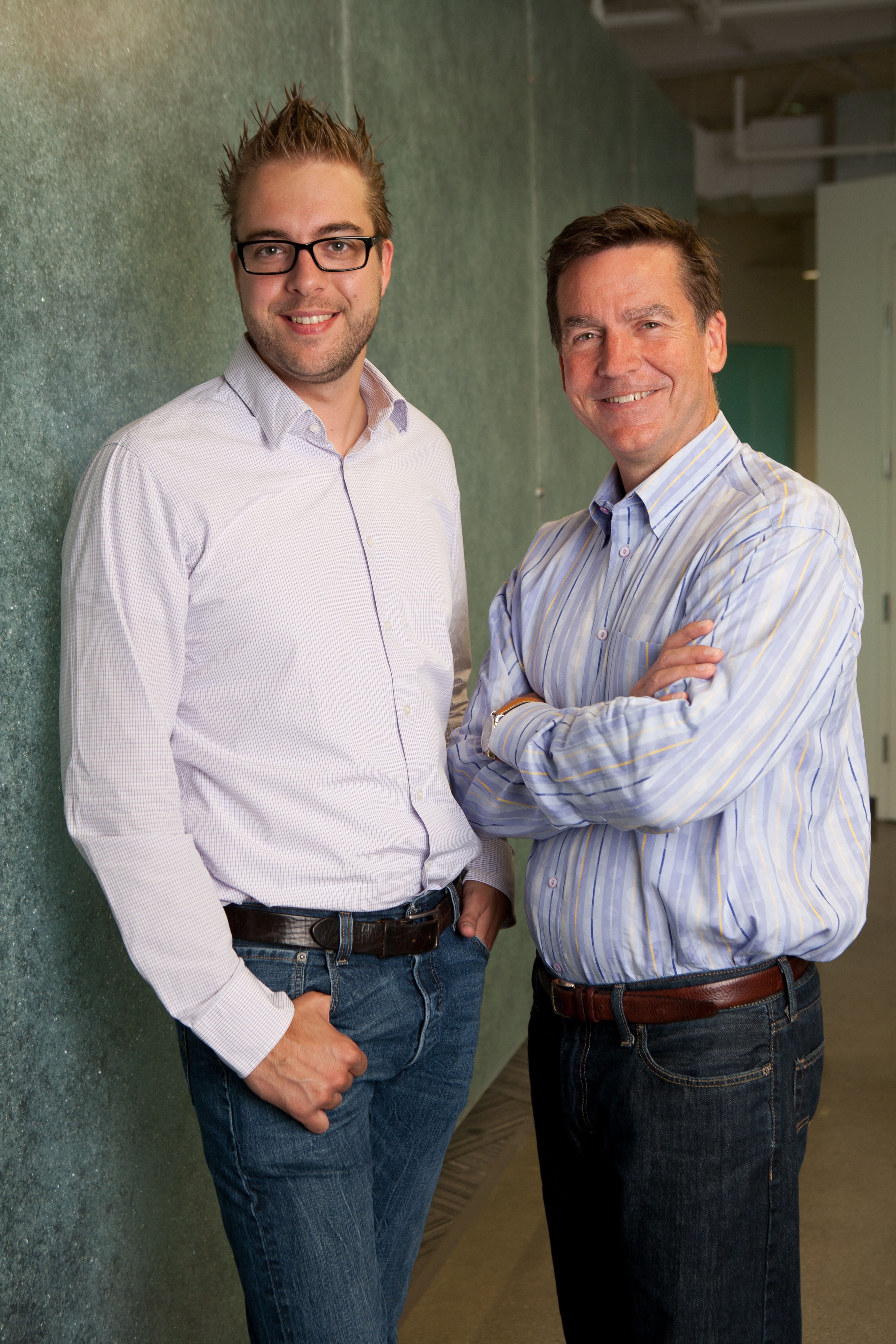 Two men stand side by side, smiling at the camera.