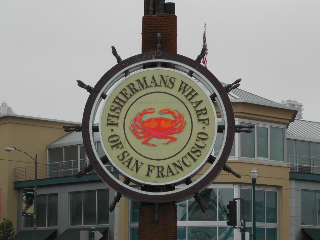 A large circular sign reads "Fisherman's Wharf of San Francisco", featuring a red crab in the center.