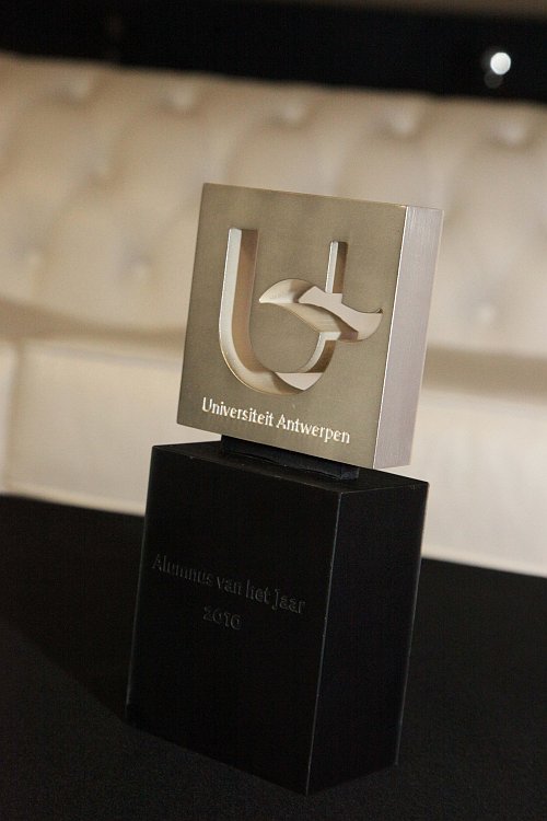 A trophy with the University of Antwerp logo and "Alumnus van het Jaar 2010" engraved on the base.