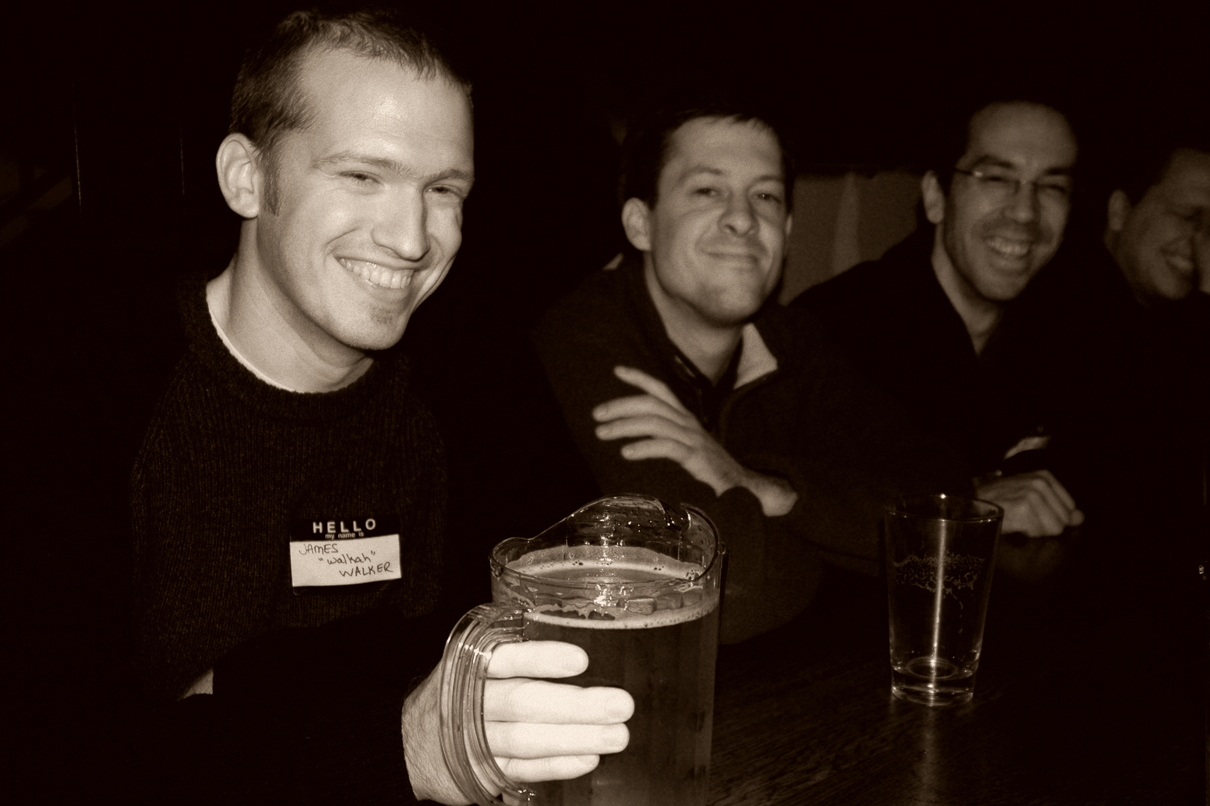 Three men sitting at a table, smiling.