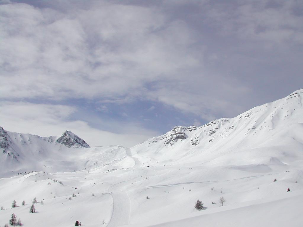 Snow-covered mountains with a ski trail winding through the landscape.