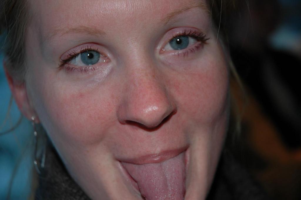 Close-up of a person sticking out their tongue and looking directly at the camera.