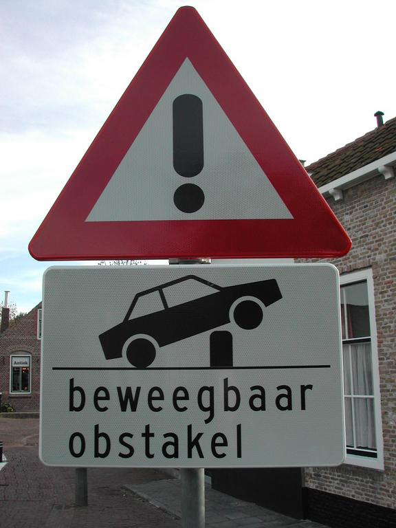 Warning sign indicating a movable obstacle that may affect vehicles on the road.