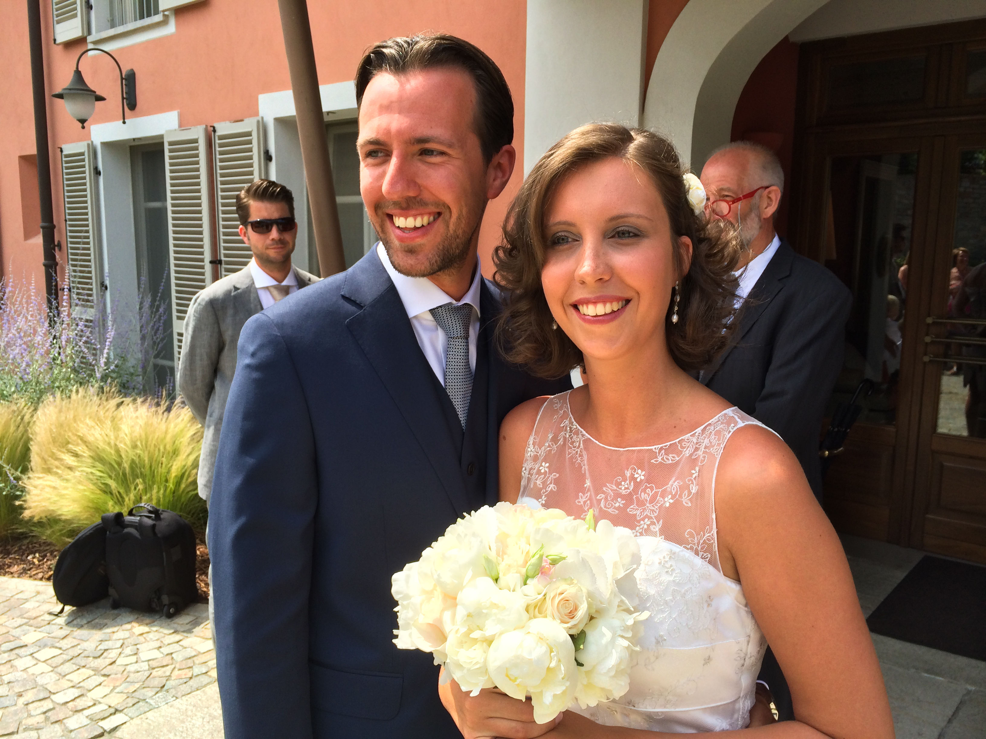 The bride and groom smile while posing for a photo.