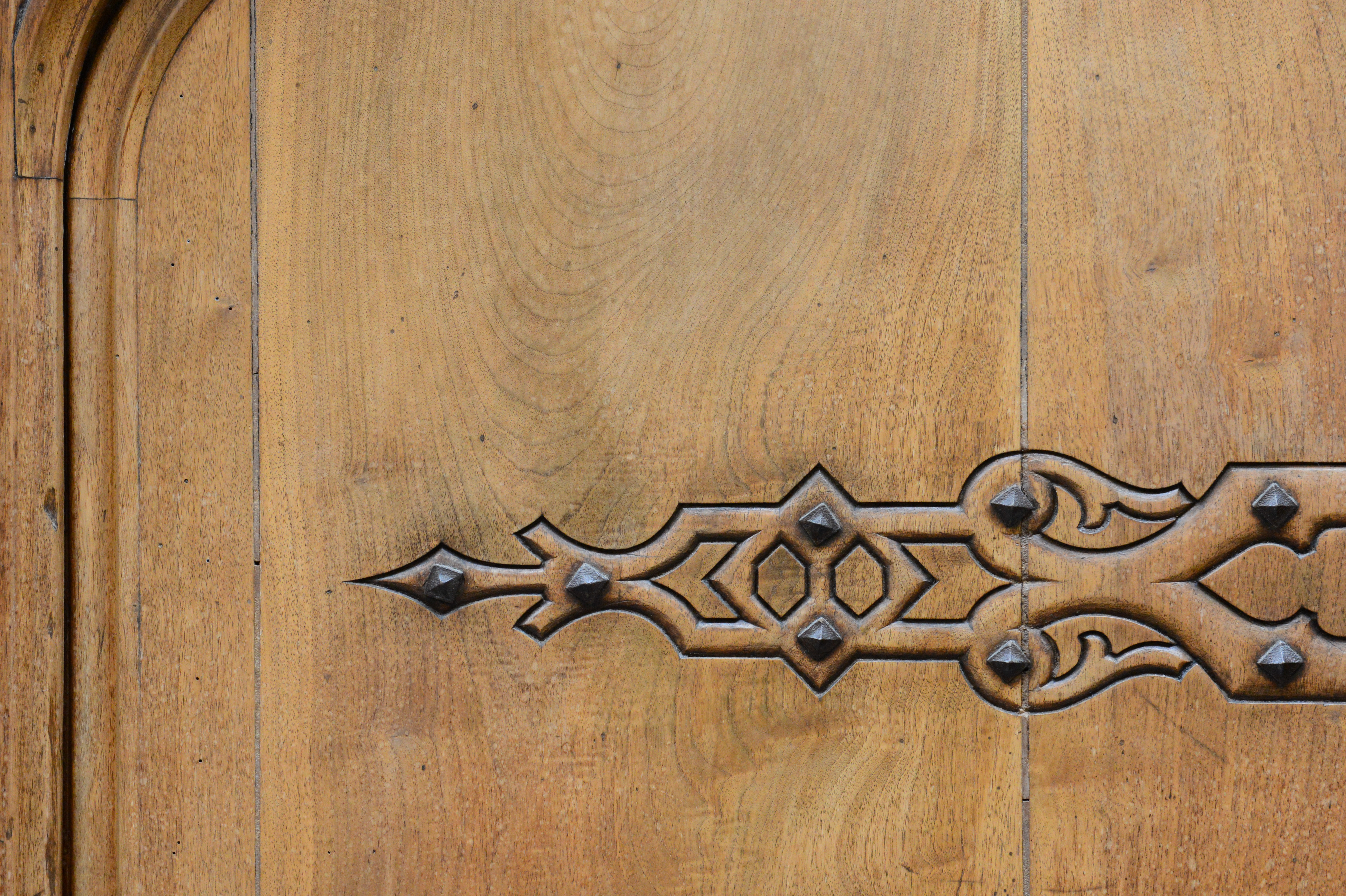 A close-up of a wooden door with decorative metal hinges, possibly part of a wedding venue entrance.